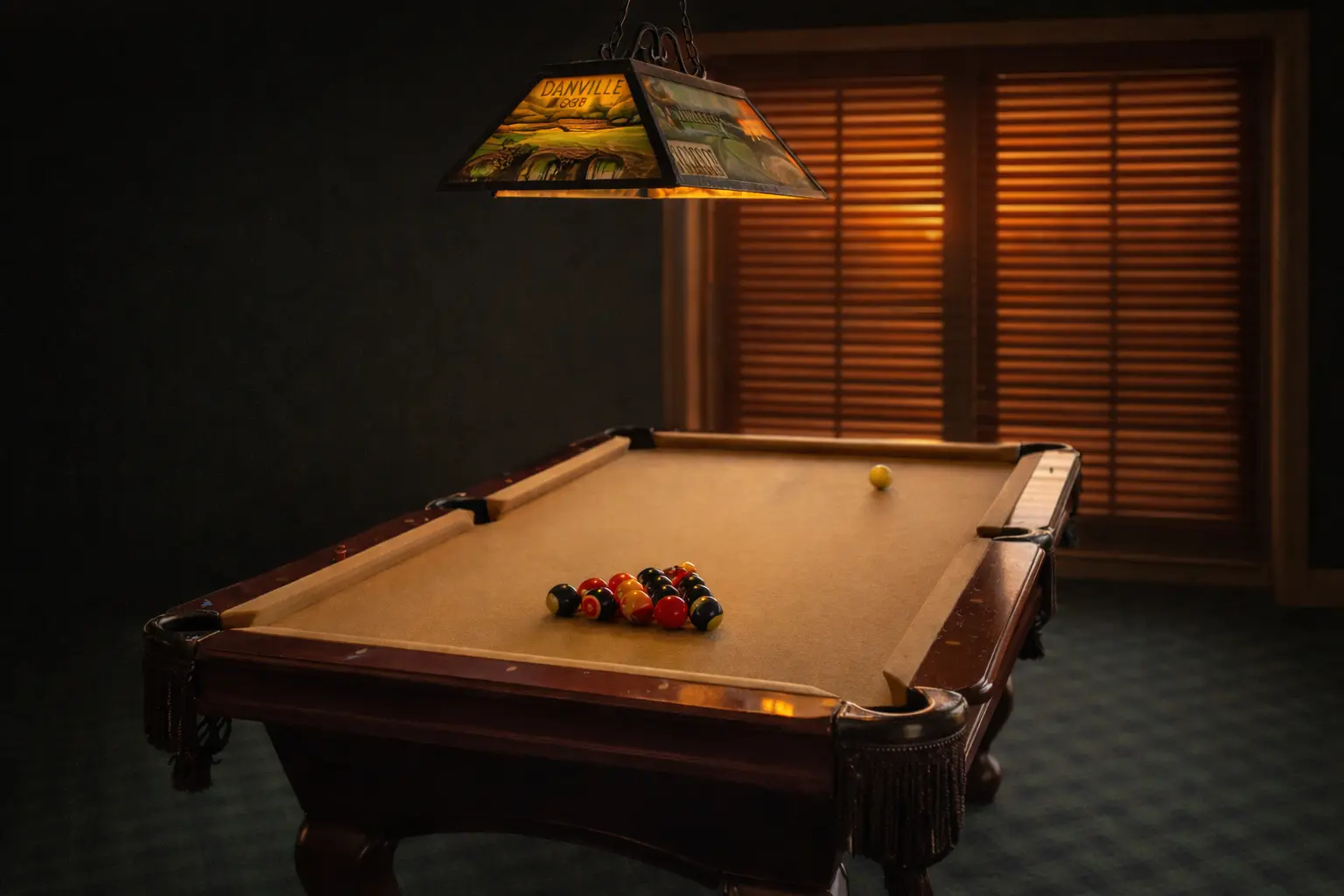Game room poker table with TV and billiards setup at Danville Golf Club